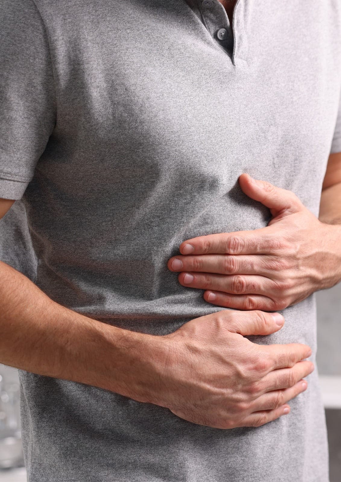 General physician consulting a patient about gastrointestinal disorders in a modern clinic, calm and professional environment, realistic medical photography, no text in image